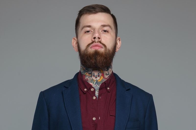 Man with neck tattoos wearing suit