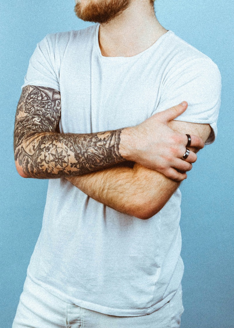 Man with forearm tattoo crossing arms